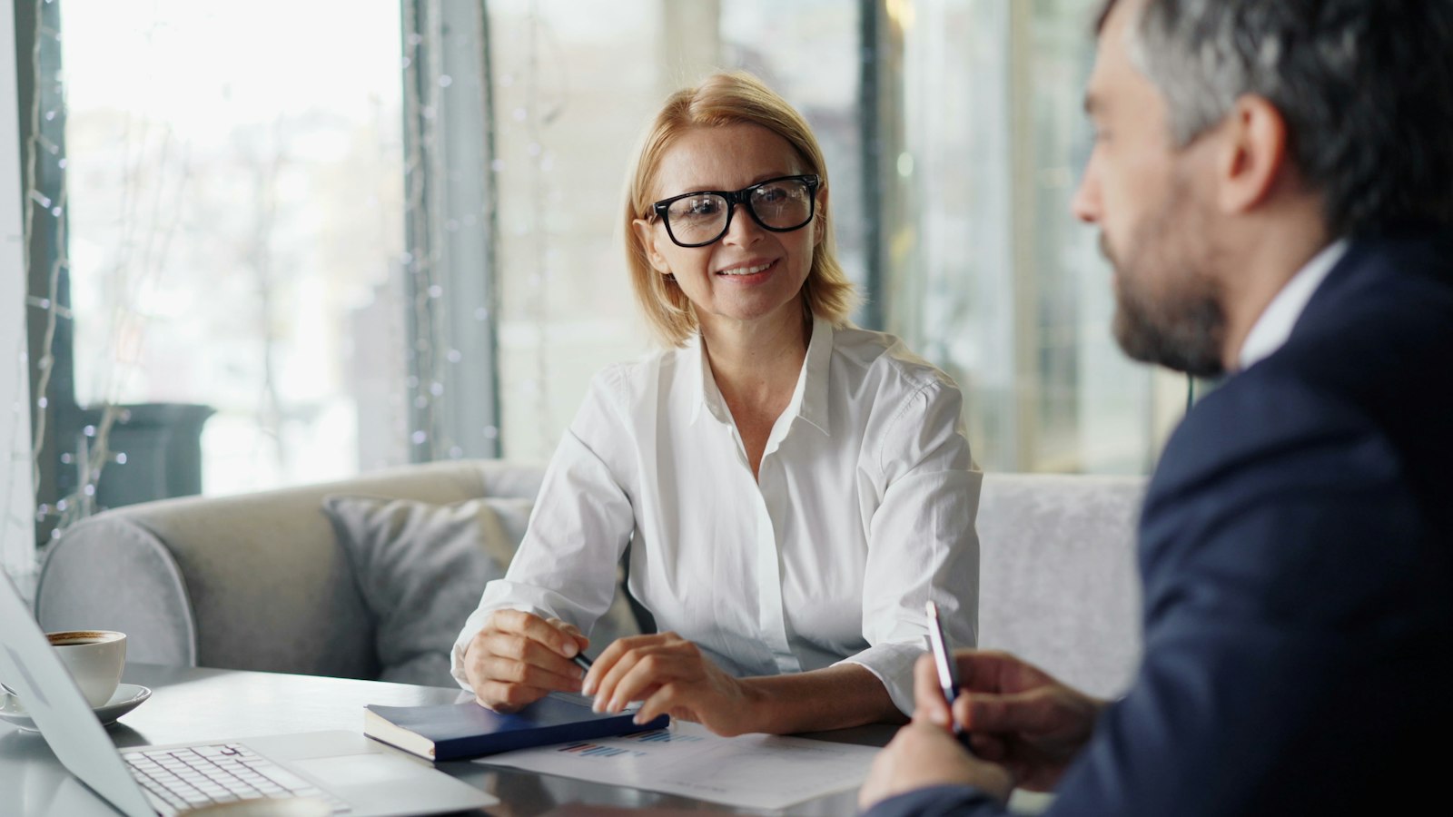 A family lawyer listening to a client across a desk during a first meeting